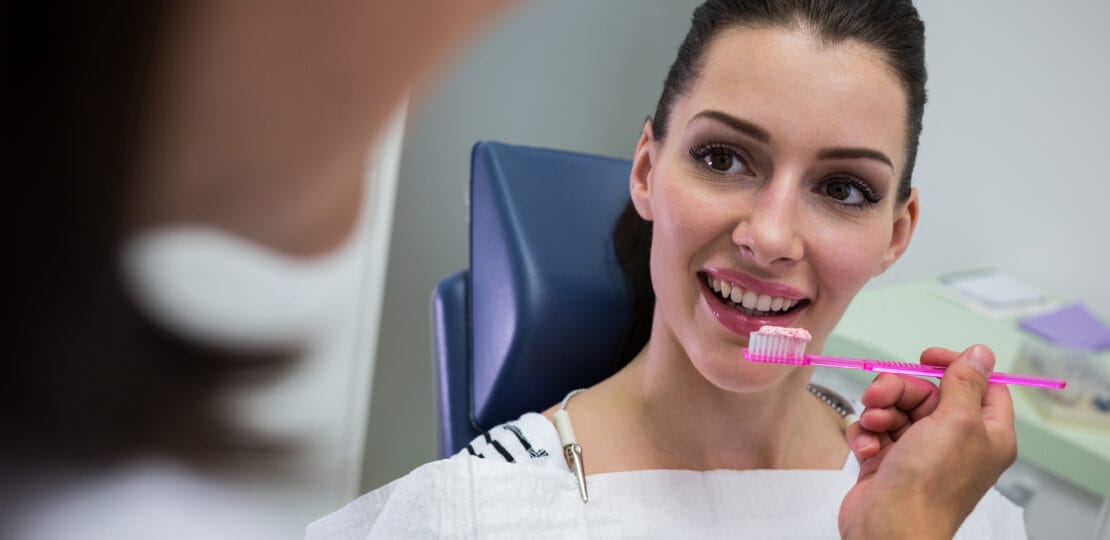 Dentist holding a brush in front of patient at clinic